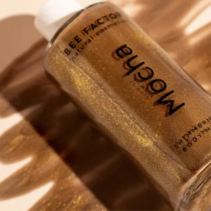 Close-up van Bee Factor Glow Up Mocha op bronskleurige satijnen stof.