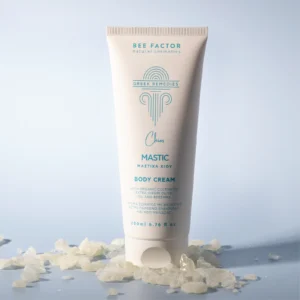 Witte tube Bee Factor-bodycrème met mastiek tussen mastiekhars op een lichtblauwe achtergrond.
