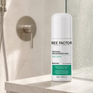 Bee Factor natuurlijke deodorantmelk, 50 ml, op een stenen plank naast een douchewand.